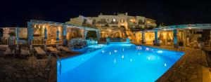 a large swimming pool with blue lights on it at night at Sunset View Hotel in Parikia