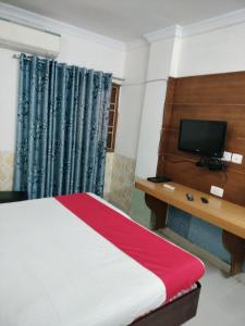 a hotel room with a bed and a television at Sun Classic Residency in Chennai