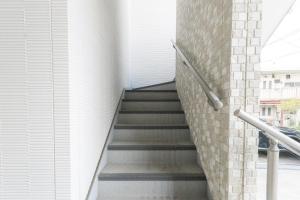 a staircase in a building with a brick wall at Rojuman Hakata in Hakata