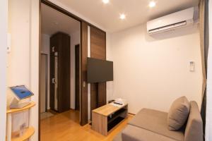 a living room with a couch and a flat screen tv at Rojuman Hakata in Hakata +26 photos
