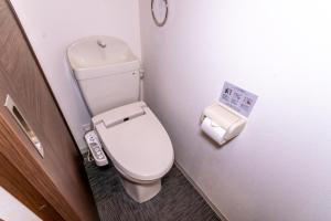 a small bathroom with a toilet and a trash can at Rojuman Hakata in Hakata