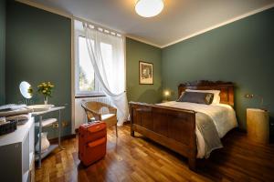 a bedroom with green walls and a bed and a window at Bed and Breakfast Sweet Home in Tirano