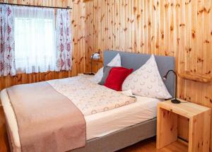 a bedroom with a large bed with a red pillow at Almhütte Tamberger in der Feldpann-Alm in Rauth