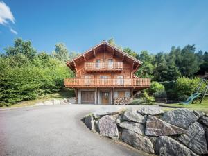 a log house with a balcony and a playground at Chalet in Vosges with Sauna & Panoramic Views in Anould