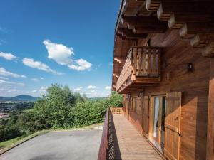 a wooden building with a balcony on the side of it at Chalet in Vosges with Sauna & Panoramic Views in Anould +25 photos