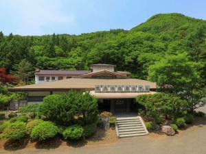 a large building with a mountain in the background at Iwaizumi Ryusendo Hotel Ryunosumika in Iwaizumi