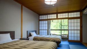 a bedroom with two beds and a large window at Iwaizumi Ryusendo Hotel Ryunosumika in Iwaizumi +45 photos