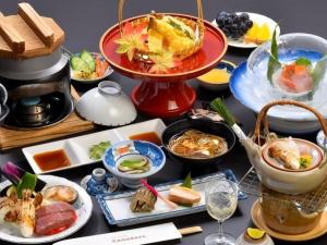 a table topped with plates of food on a table at Iwaizumi Ryusendo Hotel Ryunosumika in Iwaizumi