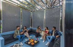 a group of people sitting on a couch at EKOSTAY - Forestwood Villa in Alibaug
