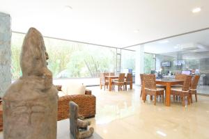 ein Wohnzimmer mit Tisch, Stühlen und einer Statue in der Unterkunft Hotel Ventura in Bucaramanga