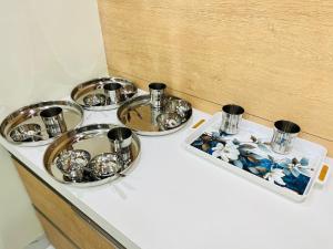 a tray with four bowls and cups on a counter at Book the Entire Villa or Choose a Room for a Comfortable Homestay Experience in Solapur