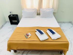 a bed with two towels and toothbrushes on it at Book the Entire Villa or Choose a Room for a Comfortable Homestay Experience in Solapur