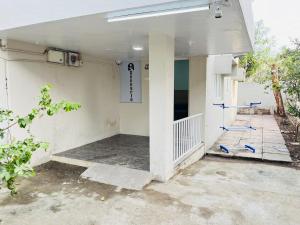 an outside view of a white building with blue chairs at Book the Entire Villa or Choose a Room for a Comfortable Homestay Experience in Solapur