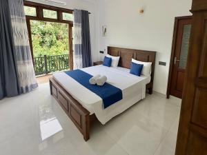 a bedroom with a large bed and a window at Lotus Manuvala - Negombo in Kochchikade