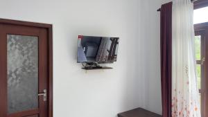 a television on a wall next to a door at Lotus Manuvala - Negombo in Kochchikade