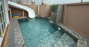 a swimming pool with a water slide in a building at Sea Flower Onsen in Ban Bo Khaem