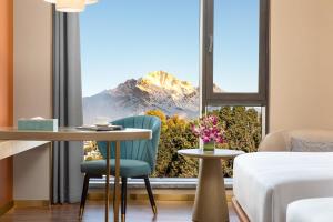 a room with a table and a window with a mountain view at Wyndham Lijiang Yulong in Lijiang