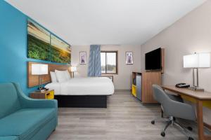 a hotel room with a bed and a desk at Days Inn by Wyndham Austin in Austin