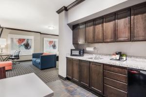 a kitchen with a counter and a living room at Hawthorn Suites by Wyndham Lubbock in Lubbock