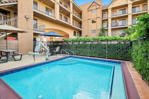 a swimming pool with a patio and a building at Howard Johnson by Wyndham Pasadena in Pasadena