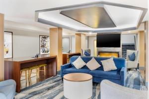a living room with a blue couch and a tv at Comfort Inn & Suites El Paso I-10 Airport Area in El Paso