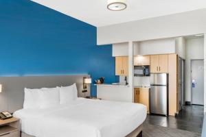 a large white bed in a room with a kitchen at Comfort Inn & Suites El Paso I-10 Airport Area in El Paso +26 photos