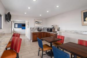 a kitchen and dining room with tables and chairs at Travelodge by Wyndham Albuquerque West in Albuquerque