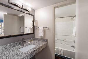 a bathroom with a sink and a mirror at Travelodge by Wyndham Albuquerque West in Albuquerque +30 photos