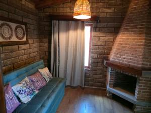 a living room with a couch and a brick wall at cabañas el rio alcatraz in Zacatlán