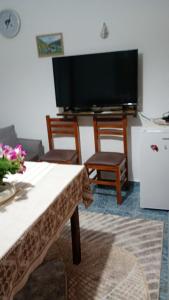 a living room with a tv and a table and chairs at Aleko Guesthouse in Përmet
