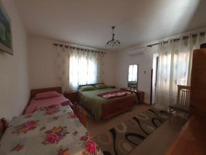 a bedroom with two beds and a window at Garden Home near Osum Canyon & Cooking Experience in Çorovodë