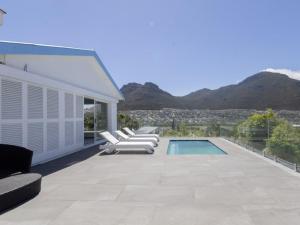 a patio with lounge chairs and a swimming pool at Villa Mykonos in Cape Town