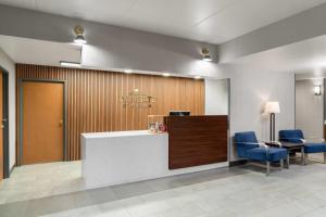 a lobby with a reception desk and blue chairs at Wingate by Wyndham Clearfield in Clearfield +57 photos