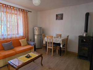 a living room with a couch and a table at Garden Home near Osum Canyon & Cooking Experience in Çorovodë