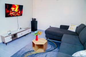 a living room with a blue couch and a fireplace at NayaLoft in Naivasha