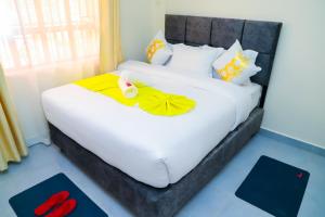 a bedroom with a white bed with two rubber ducks on it at NayaLoft in Naivasha