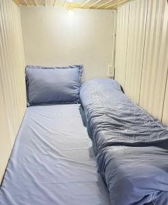 a bed in a room with blue sheets and pillows at Hostel 405 Sa Pa in Sapa