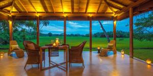 a dining room with a table and chairs on a patio at Maya Tangalle Luxury Wellness-Adults Only-Free Unlimited Shuttle service to our private Beach in Tangalle
