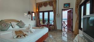 a bedroom with a bed and a view of a balcony at Phonevichith Riverside Hotel Houayxai in Ban Khonkèo