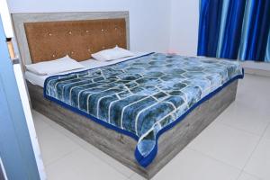 a bed with a blue comforter on top of it at Nirmala Garden in Bamiana