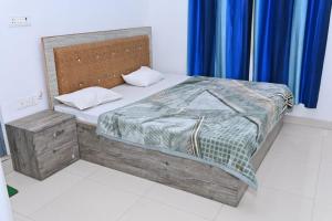 a bedroom with a bed with a wooden headboard at Nirmala Garden in Bamiana