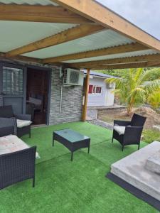 a patio with awning and chairs and a table at Chalet Les Planifolias in Saint-Philippe