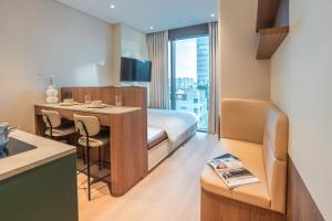 a hotel room with a bed and a desk with a table at Weave Suites - Sunyu Parkside in Seoul