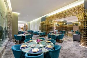 a restaurant with blue tables and chairs and a large wall at Wyndham Lijiang Yulong in Lijiang