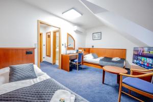 a hotel room with two beds and a desk at Hotel Belcredi in Brno +134 photos