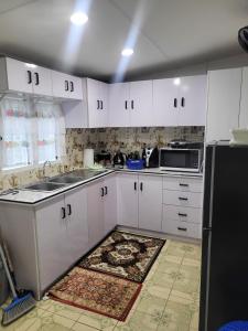 a kitchen with white cabinets and a black refrigerator at Coastal Paradise in Sigatoka