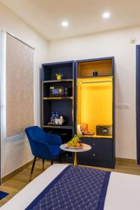 a room with a blue chair and a table at The PratiQ Neo - Meera Bagh in New Delhi