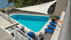an overhead view of a swimming pool with chairs and an umbrella at Villa Marina in Omiš