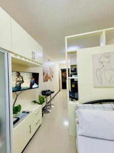 a bedroom with a bed and a flat screen tv at STUDIO WITH BALCONY at the HEART of DAVAO CITY in Davao City