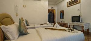 a hotel room with two beds and a television at Phonevichith Riverside Hotel Houayxai in Ban Khonkèo +12 photos